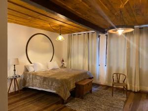 ラブラス・ノーヴァスにあるChalé da Mata Lavras Novasのベッドルーム(大型ベッド1台、大きな鏡付) +3枚の写真