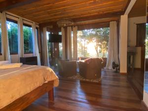 ラブラス・ノーヴァスにあるChalé da Mata Lavras Novasのベッドとリビングルームのある寝室