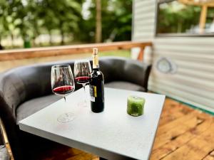 een fles wijn en twee glazen op een tafel bij Holenderek Agro-Stajnia in Rudniki +3 foto's