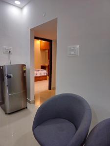 a blue chair in a room with a refrigerator at VEDHA Homestay in Tirupati