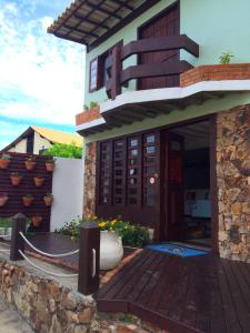 una casa con un ponte di legno di fronte ad essa di Pousada Do Capitão ad Arraial do Cabo