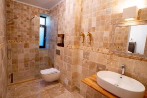 a bathroom with a toilet and a sink and a mirror at Vila Valeria in Techirghiol
