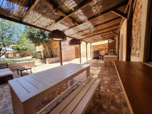 a dining room with a wooden table and a bench at Casa Can Bernat in Santanyi
