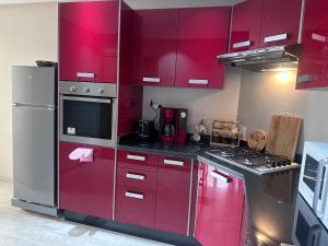 cocina con armarios rojos y nevera en Luxury By Sana, en Agadir