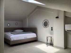 a bedroom with a bed and a mirror and a stool at Alkyon Apartments Studios in Platanitis