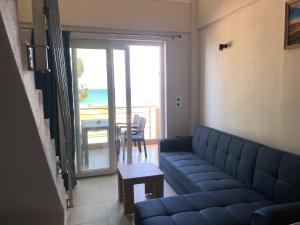 a living room with a couch and a view of the ocean at Alkyon Apartments Studios in Platanitis