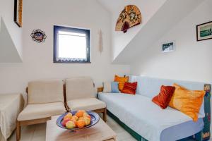 a living room with a couch and a bowl of fruit on a table at Apartment with beautiful view and big terrace in Vrboska +4 photos