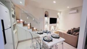 a white living room with a table and a couch at D'Blue Búzios Hotel Boutique in Búzios