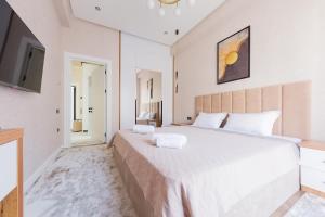 a bedroom with a large white bed and a television at 7, 8, Tashkent City Park, Boulevard, 51m2 in Tashkent +29 photos