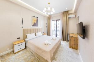a bedroom with a large bed and a television at 7, 8, Tashkent City Park, Boulevard, 51m2 in Tashkent