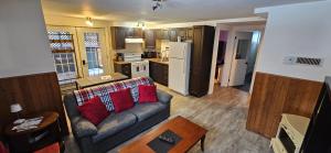 ein Wohnzimmer mit Sofa und eine Küche in der Unterkunft Le Repaire Secret in Saint-Donat-de-Montcalm