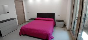a bedroom with a bed with a pink blanket at B&B Carpe Diem Domus in Lacco Ameno +9 photos