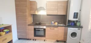 a kitchen with a sink and a washing machine at Rêve de Bisca Appartement spacieux avec jardin privatif piscine et parking privés in Biscarrosse