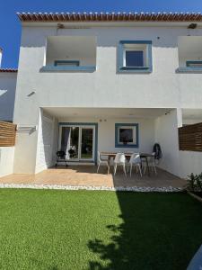 a house with a patio with a table and chairs at TALAFA Beach House - Almograve in Almograve +14 photos