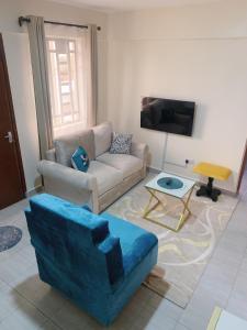 a living room with a couch and a tv at Ravic Homes Nairobi,One bedroom in Nairobi