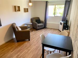a living room with chairs and a table and a television at Lisbon Woods House in Lisbon