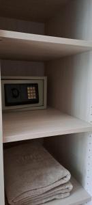 a microwave sitting on a shelf in a closet at Viena Rooms & Apartments in Palaiochóra