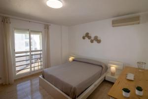 a bedroom with a bed and a table and a window at Apartamento superior - Alcocebre in Alcossebre +25 photos