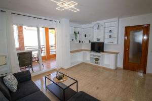 a living room with a couch and a tv and a table at Apartamento superior - Alcocebre in Alcossebre