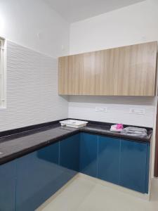 a kitchen with blue cabinets and a counter top at VEDHA Homestay in Tirupati