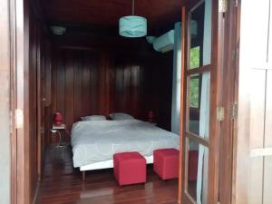 Ένα ή περισσότερα κρεβάτια σε δωμάτιο στο Bungalow confortable à Ruisseau avec piscine partagée