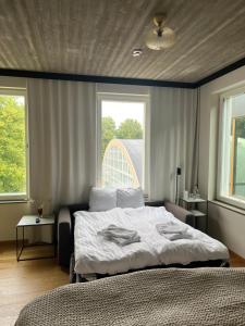 a bedroom with a large bed and two windows at Fritiden Hotell & Kongress in Ystad