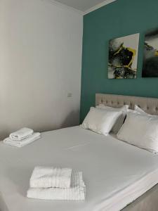 a white bed with two towels on top of it at Private room in Gjirokastër