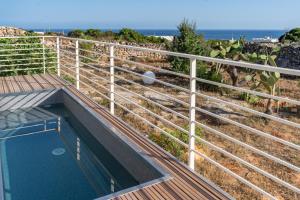 a swimming pool with a fence next to the ocean at Il Cubo by LoveSud in Castrignano del Capo +26 photos
