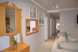 a living room with a couch and a mirror at Eagles Rest Cottage in Greytown
