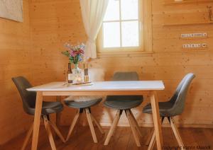 a dining room table with chairs and a vase of flowers at Das Paradieschen Edlitz - stilvolles Blockhaus mit Kamin in Edlitz