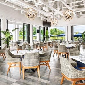 a dining room with tables and chairs and windows at Casa Lago 5 Bed Waterfront House in Innisfil