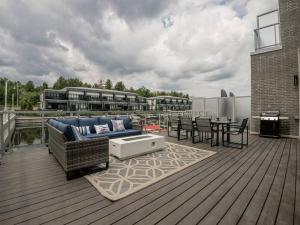 a patio with a couch and a table on a deck at Casa Lago 5 Bed Waterfront House in Innisfil