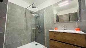 a bathroom with a shower with a sink and a mirror at Appartement T3 A Marina 2 LUMIO in Lumio +16 photos