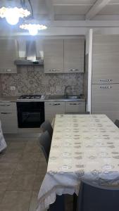 a kitchen with a table and a kitchen with white cabinets at Home Giove in Giardini Naxos
