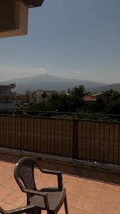 a chair sitting on top of a balcony at Home Giove in Giardini Naxos