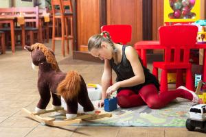 a woman sitting on the floor with a wooden dog statue at Penzion Larion in Kráľová Lehota