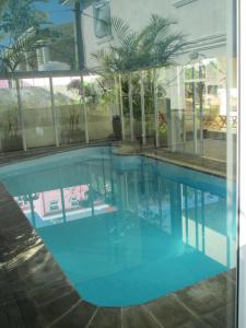 a large swimming pool with blue water in a building at Sacha Tourist Residence 1 in Mahébourg