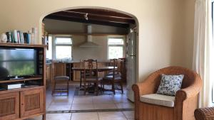 a living room with a tv and a table and chairs at Tropical Apartment in Tamarin