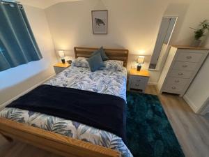 a bedroom with a bed with two night stands and two lamps at The Stables at Hustyn Gate in Wadebridge