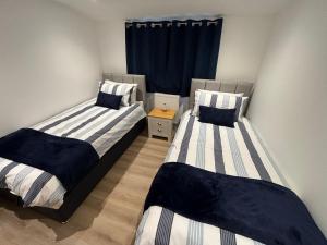 two twin beds in a room with a window at The Stables at Hustyn Gate in Wadebridge