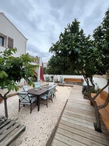 a patio with a table and chairs and trees at La bodeguita terrasse in Saint-Génis