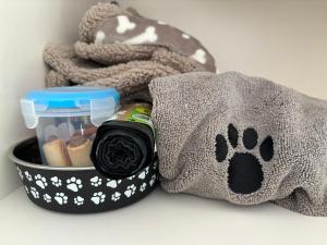 a container with a dog paw print next to a towel at The Stables at Hustyn Gate in Wadebridge