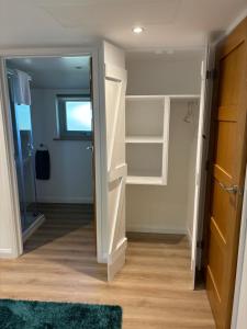 a bathroom with a walk in closet and a mirror at The Stables at Hustyn Gate in Wadebridge