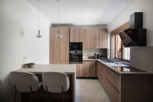 a kitchen with a counter and some chairs in it at Plaka House - Boutique Apartments in Athens