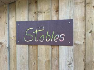 a sign on the side of a wooden wall at The Stables at Hustyn Gate in Wadebridge