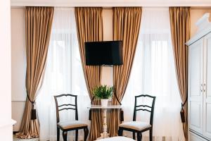 a room with two chairs and a table with a tv at Casa Salzburg in Sibiu