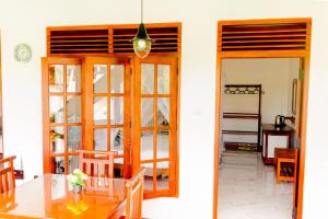a dining room with a table and glass doors at Samiru Guest Inn Ella in Ella