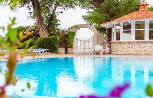 una piscina con gazebo e una casa di La Rotonda a Mattinata