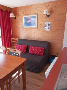 a living room with a couch and a table at Les Villages du Bachat à Chamrousse 1700 - Droseras D12 Classé 3 étoiles in Chamrousse
