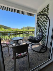 a patio with a table and chairs on a balcony at Apartment Kovach Kuti in Herceg-Novi